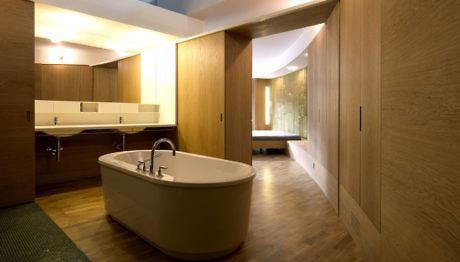 Contemporary bathroom with wood paneling and freestanding tub.