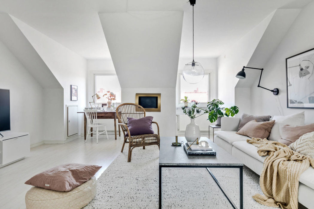 Bright, minimalist living room with sloped ceilings and contemporary decor.