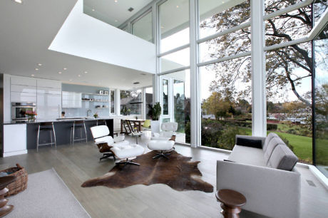 Modern open-plan living room with large windows and minimalist decor.