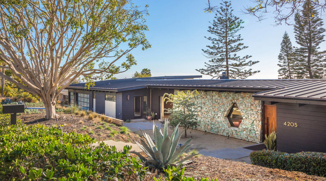 Single-story mid-century house with stone accent wall.