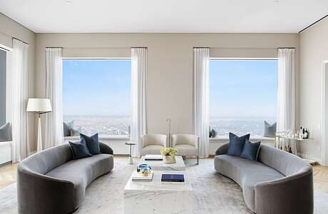 Spacious living room with panoramic city views, contemporary furnishings, and neutral color palette.