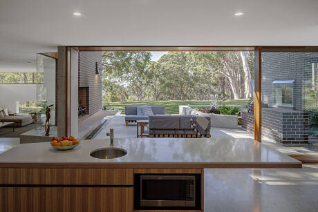Expansive glass walls frame a peaceful outdoor scene, highlighting the home's modern design.
