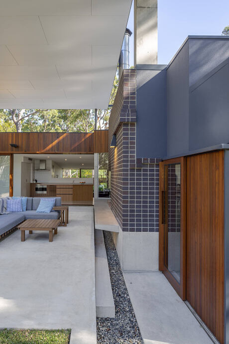 Sleek modern architecture with wooden accents, concrete surfaces, and tiled exterior.