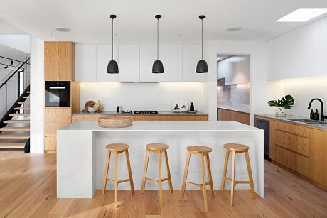 Modern kitchen interior with wooden cabinetry and a white island.