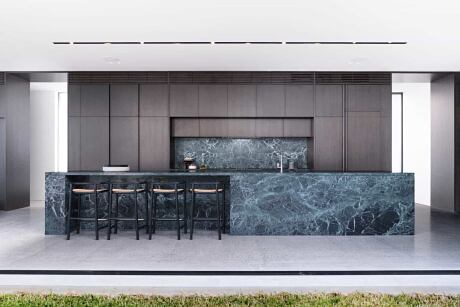 Sleek kitchen with dark cabinetry and marble island.