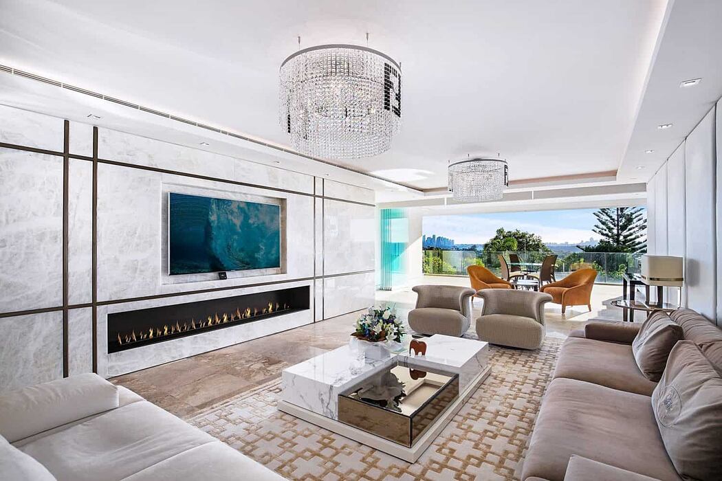 Elegant living room with modern fireplace, chandelier, and expansive view.