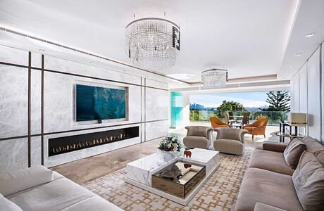 Elegant living room with modern fireplace, chandelier, and expansive view.