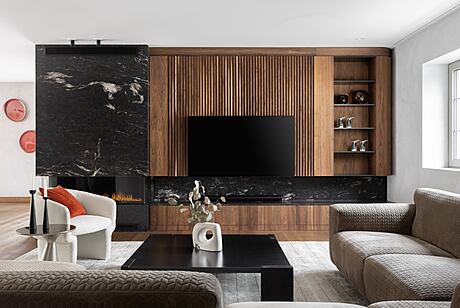 Minimalist living room with sleek wood paneling, black marble accents, and built-in shelving.