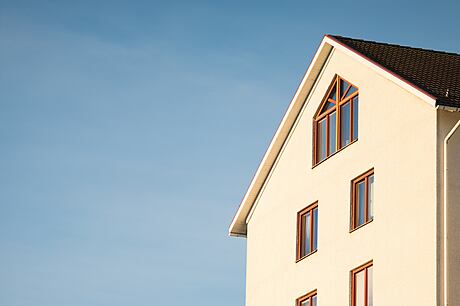 White modern house facade against a clear blue sky.