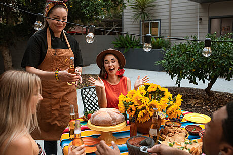 Festive outdoor patio with string lights, planter, and colorful table setting.