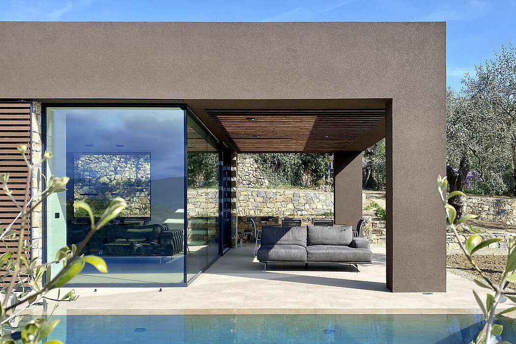 Sleek house with large glass doors, pool, and olive trees.