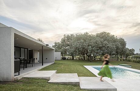 Contemporary single-story home with minimalist design, outdoor pool, and lush greenery.