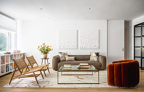 Modern living room with sofa, chairs, and marble table.