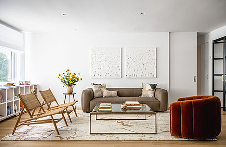 Modern living room with sofa, chairs, and marble table.