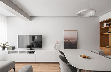 Minimalist living room with white walls, modern furniture, and wood accents.