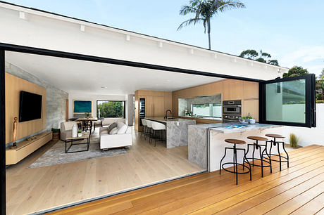 Open-plan living room and kitchen with modern decor and large windows.