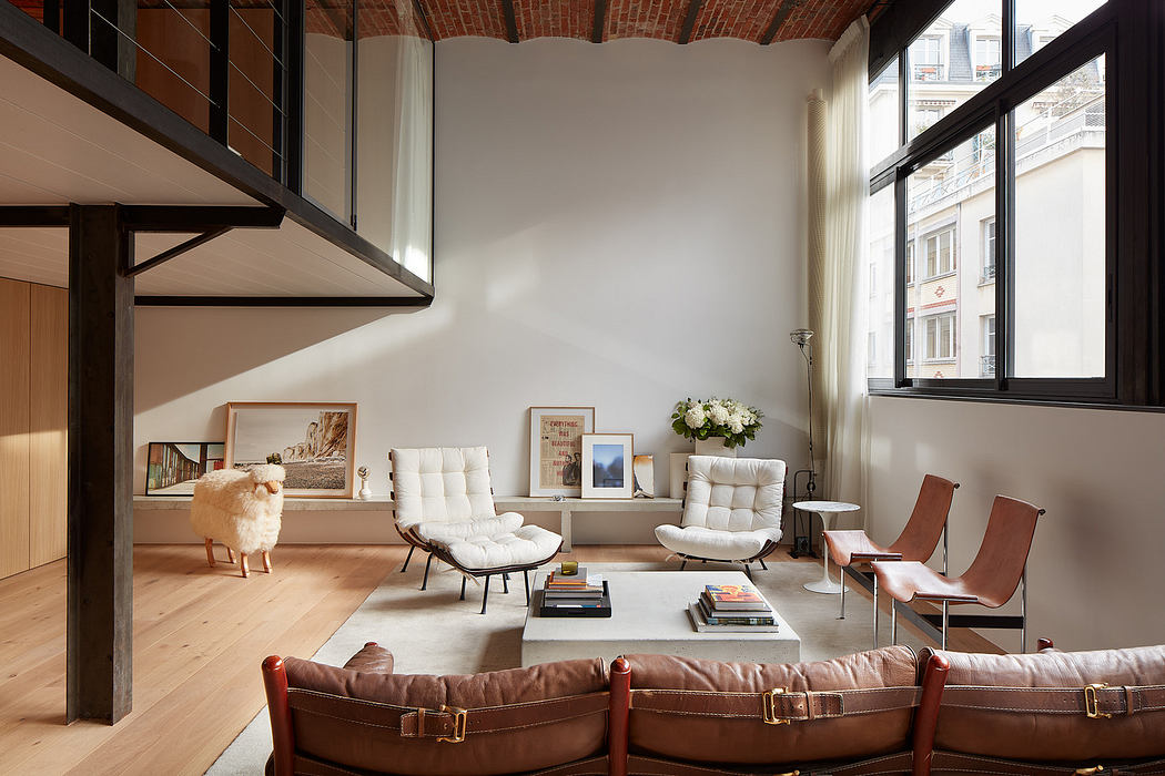 Modern living room with leather chairs, white sofas, and exposed brick walls.