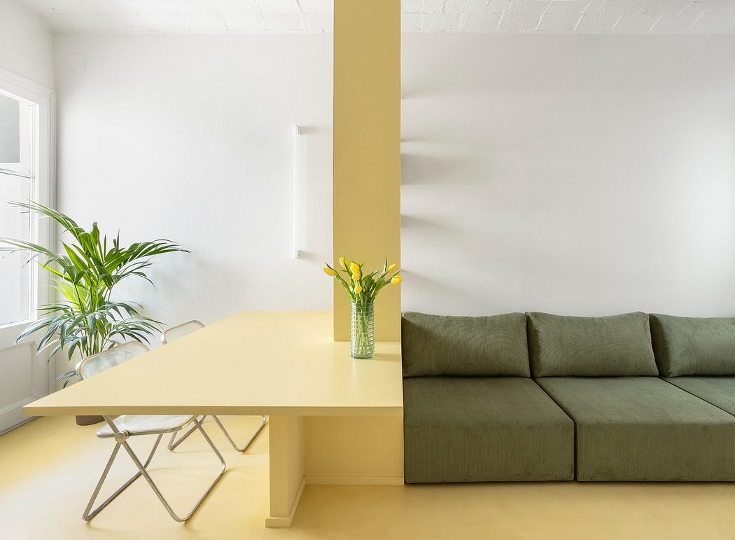 Modern minimalist interior with yellow table, green sofa, and indoor plants.