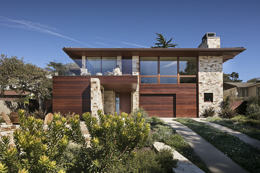 Modern house with large windows, stone walls, and a flat roof.