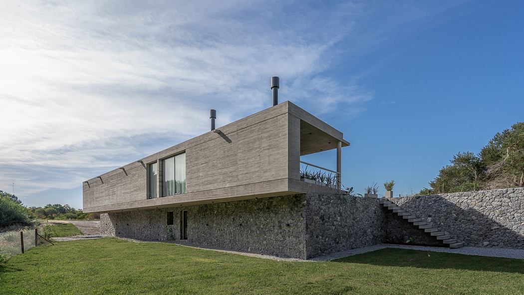 Modern house with concrete design on a grassy hillside.