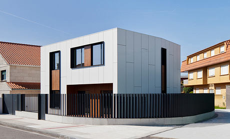 Modern two-toned house with geometric design and wooden accents.