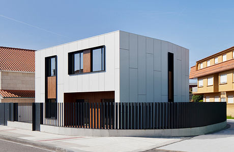 Modern two-toned house with geometric design and wooden accents.