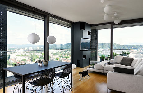 Modern living room with city view, sleek furniture, and a cat.