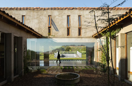 Modern courtyard with transparent walls blending indoor and outdoor spaces.