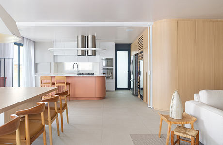 Modern open-plan kitchen and dining area with neutral colors and wooden accents.