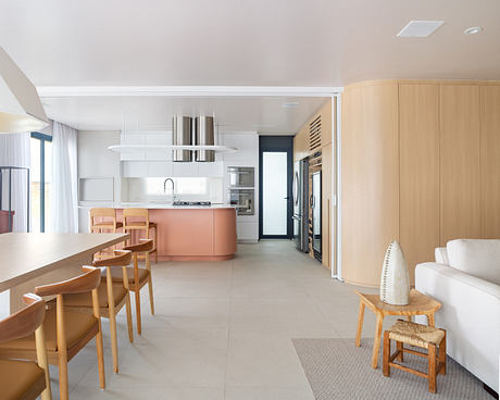 Modern open-plan kitchen and dining area with neutral colors and wooden accents.