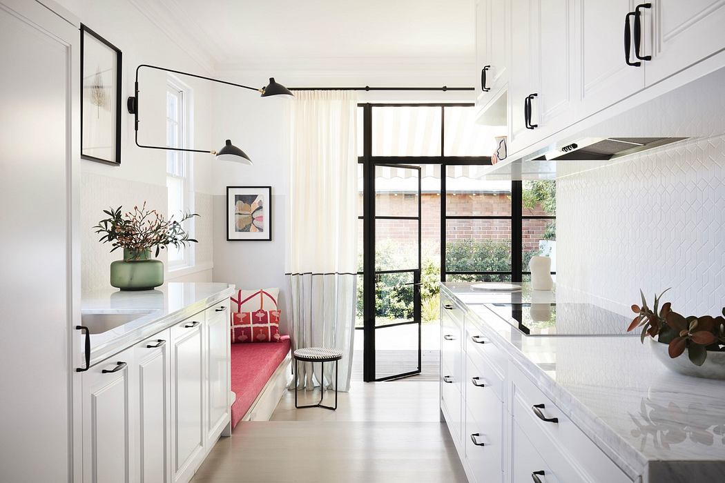 Bright, modern kitchen with white cabinetry and dining nook.