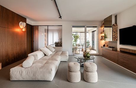 Modern living room with beige sofa, wooden accents, and minimalist decor.