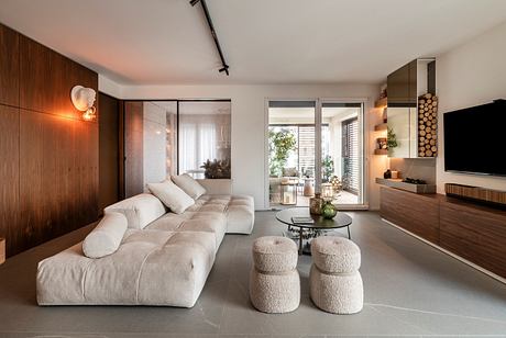 Modern living room with beige sofa, wooden accents, and minimalist decor.