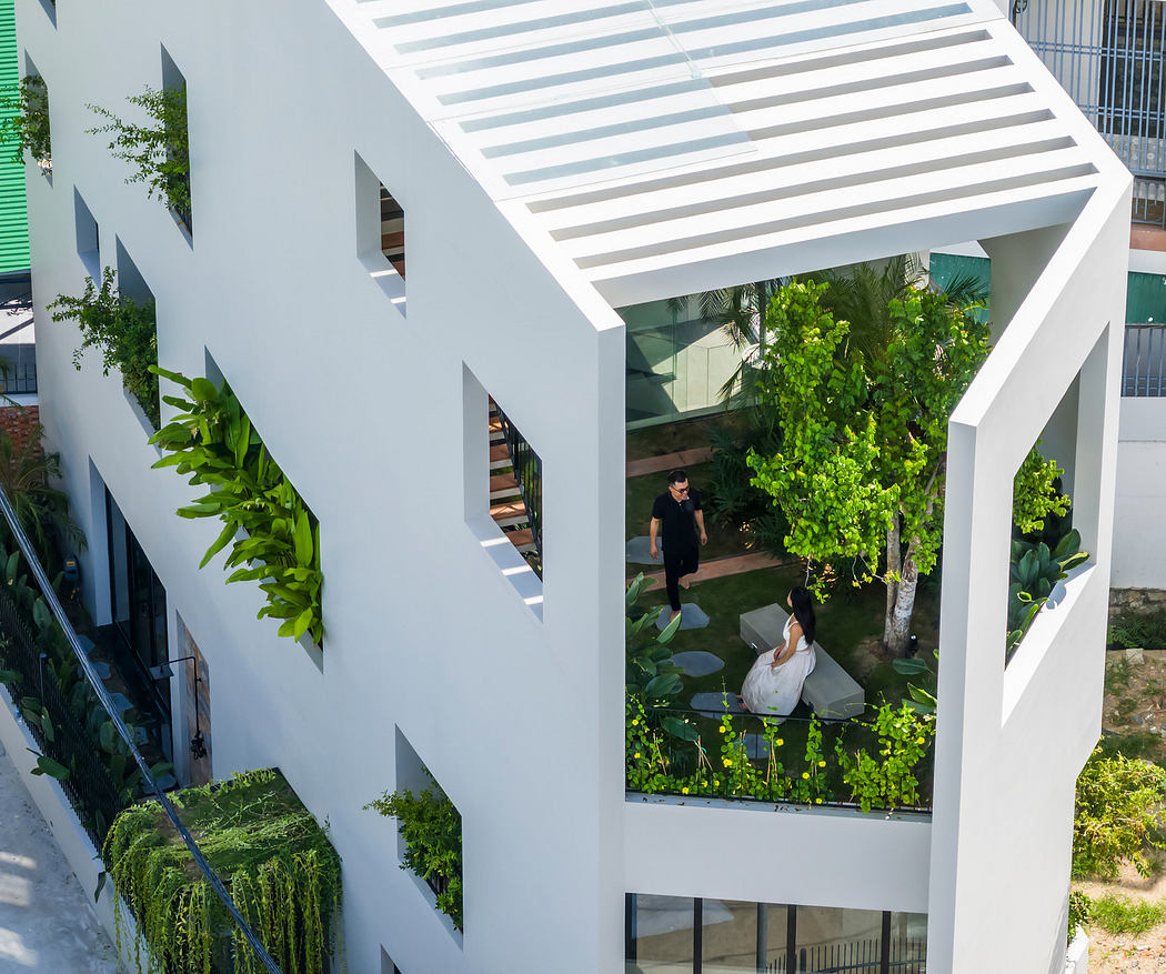 Modern building with a rooftop garden and people interacting below.