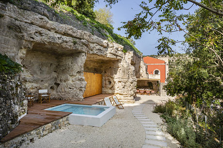 Outdoor living space incorporating natural rock formations, a wooden deck, and a small pool