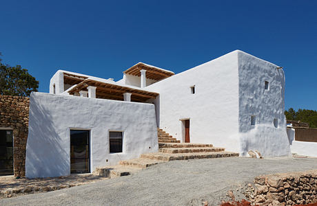 Traditional white-washed Mediterranean-style house with wooden accents.