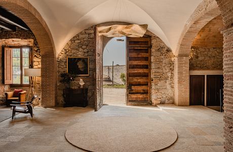 Elegant room with vaulted ceilings, stone walls, and arched wooden doors