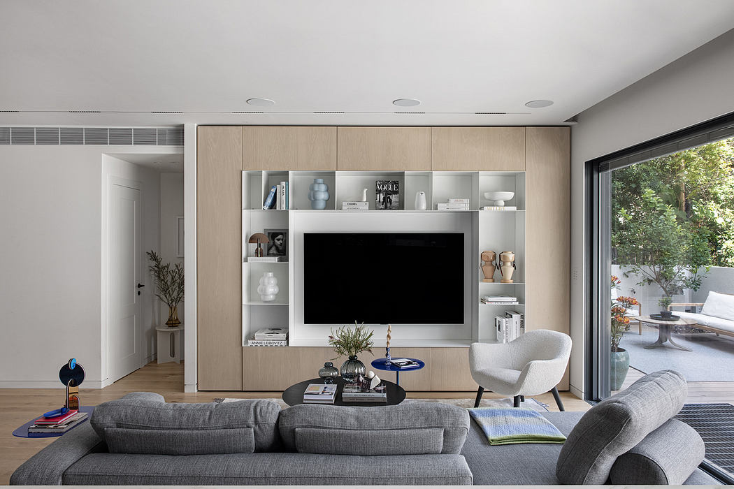 Modern living room with sleek furniture and built-in wall shelving.