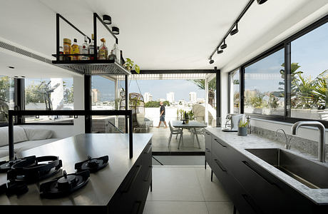 Modern kitchen with floor-to-ceiling windows and cityscape view.