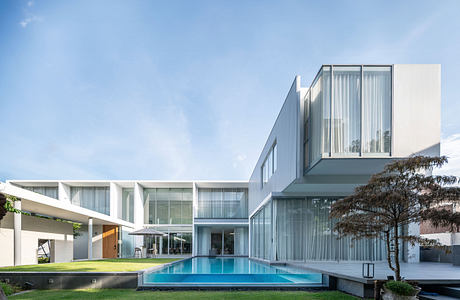 Modern white house with large windows and a swimming pool.