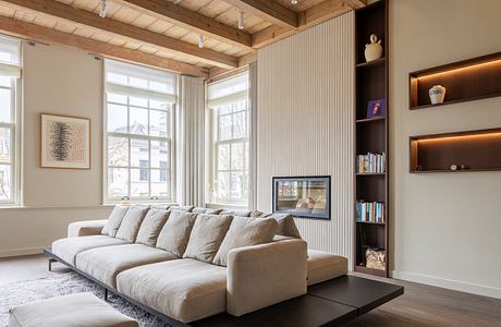 Modern living room with beige sofa, wooden ceiling, and built-in shelving.