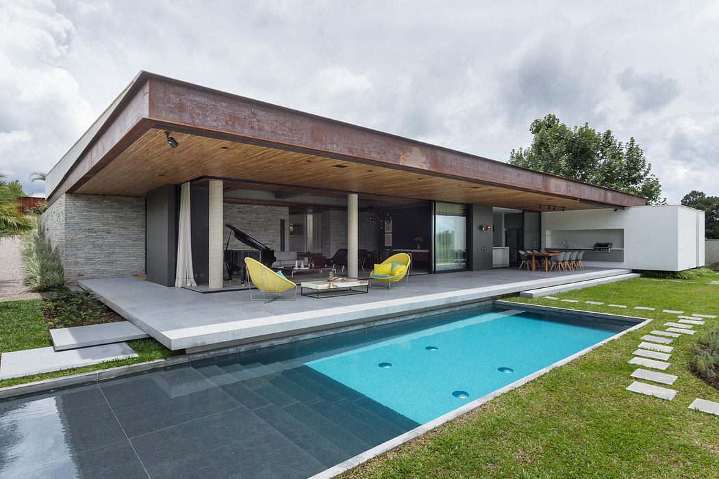 Modern home with large windows, overhanging roof, and pool.