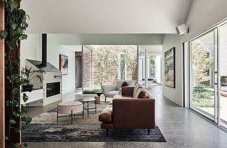 Modern living room with sleek furniture, fireplace, and floor-to-ceiling windows.