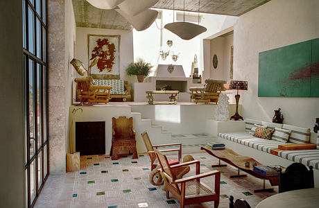 Spacious living room with eclectic decor, large windows, and patterned tile floor