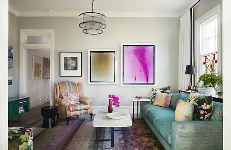 Elegant living room with colorful sofa, art pieces, and modern decor.