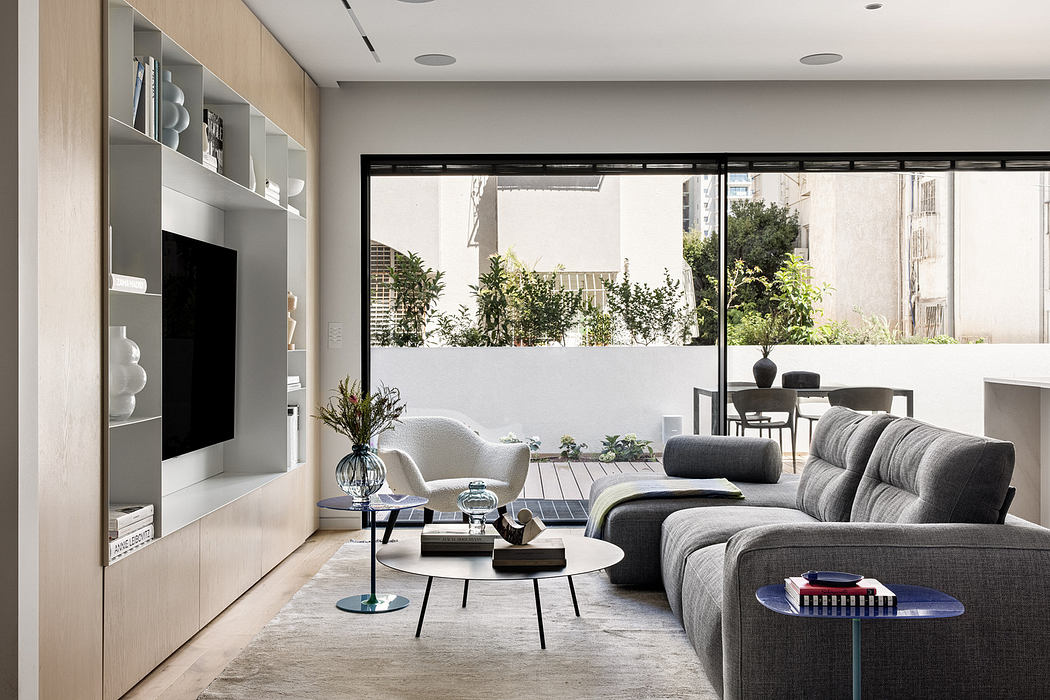 Modern living room with large window overlooking patio.