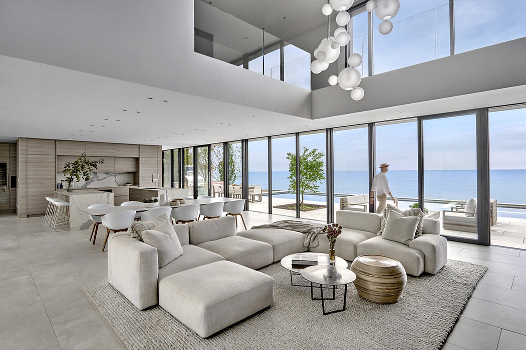 Modern beachfront living room with large windows and minimalistic decor.