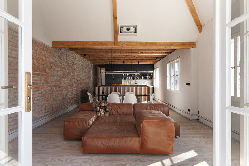 Bright, rustic-style living room with exposed beams and a large leather sofa.