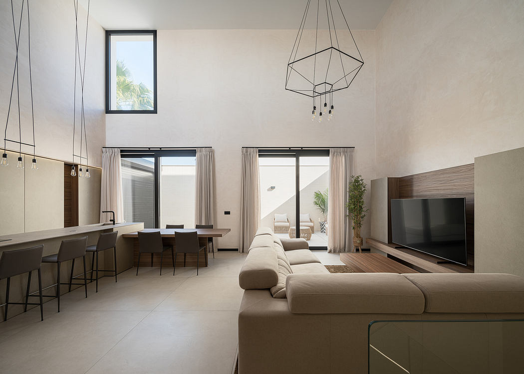 Modern living room with minimalistic decor, large sofa, and pendant lighting.