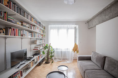 Bright modern living room with wall-mounted bookshelves and a gray sofa.